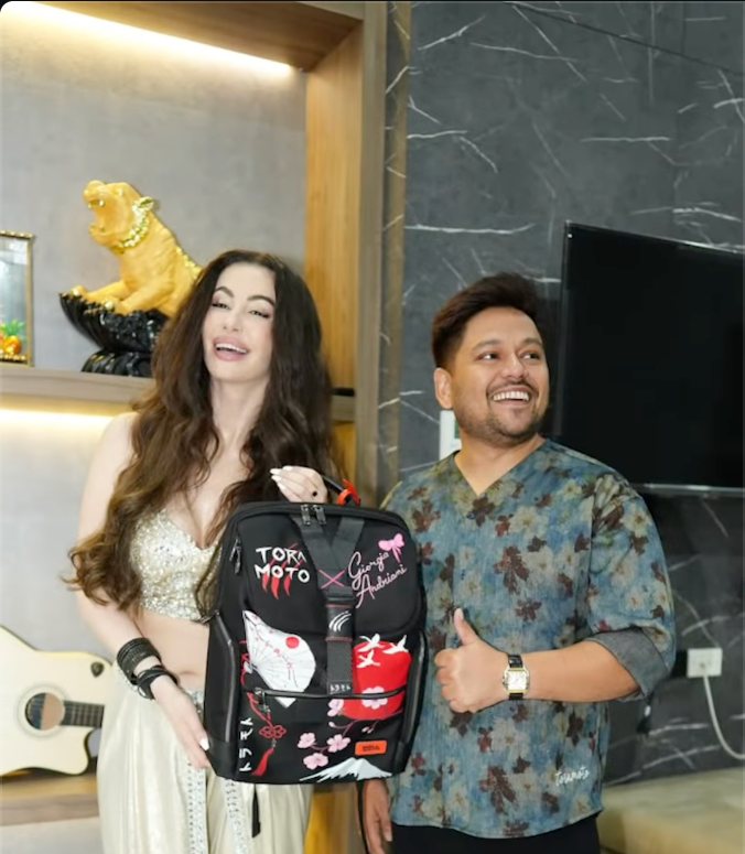 Georgia Andriani holding her custom Tora Moto bag, painted with her name